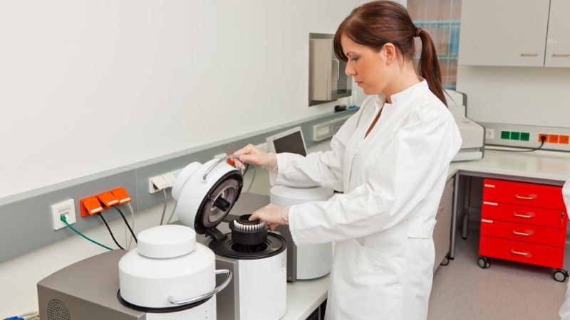 Dental technician working on custom abutments and crowns for dental implants, contributing to laboratory costs